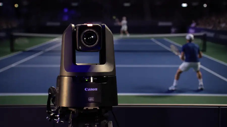 A remote-operated PTZ camera covering a tennis match from courtside.