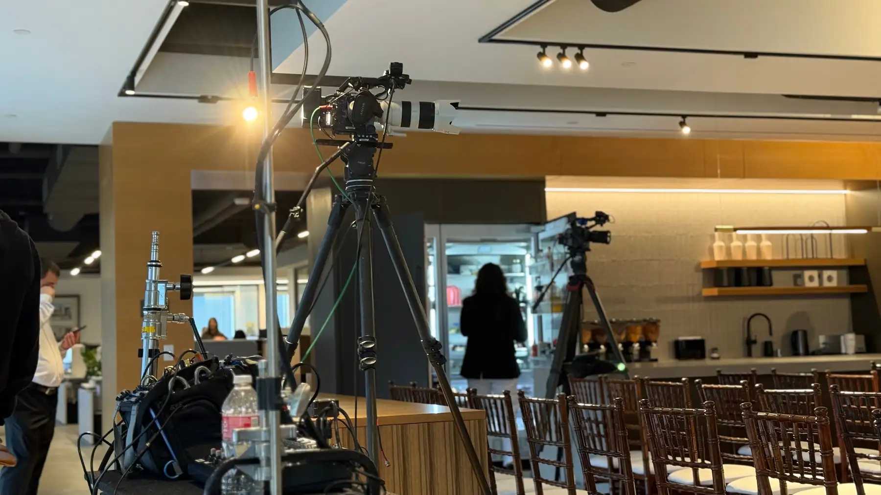 Camera position covering a corporate event stage from the rear of the room.
